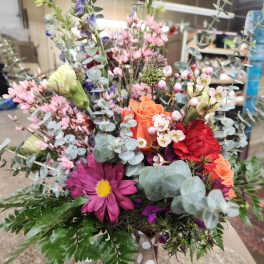 Mixed bouquet in a vase with pink, orange, red, and purple flowers