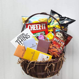 Gift basket with assorted snacks and chocolate bars in a wooden basket