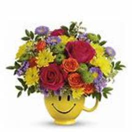 Colorful mixed bouquet in a yellow smiley-face mug