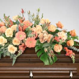 Peach and cream floral spray on a casket