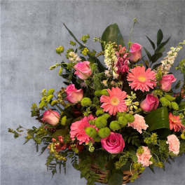 Basket arrangement of pink roses, gerbera daisies, and carnations