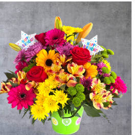 Bright mixed bouquet in a green birthday bucket with star picks