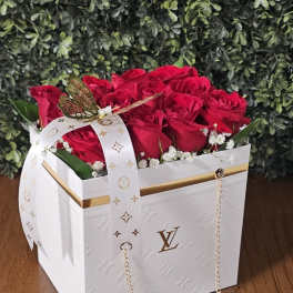 Red roses in a white gift box with a ribbon and chain strap