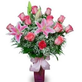 Pink roses and lilies arranged in a purple vase