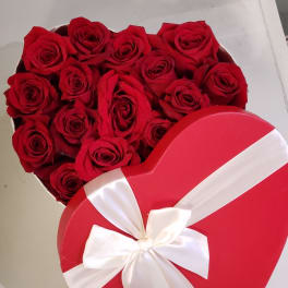 Heart-shaped box of red roses with a white ribbon bow