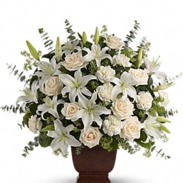 White lilies and cream roses arranged in a brown urn vase
