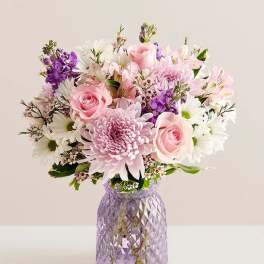 Pink and white mixed bouquet in a purple glass vase