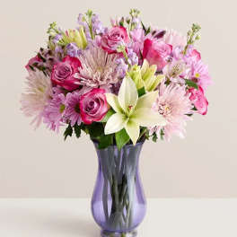 Pink and lavender mixed bouquet in a purple glass vase