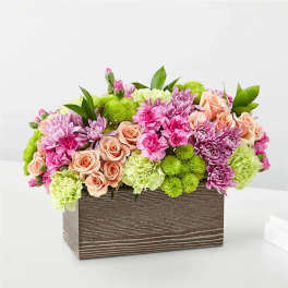 Mixed pink and green floral arrangement in a rectangular wooden box