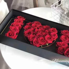 Red roses arranged in a black gift box to form the number 520