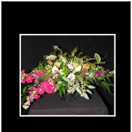 Large pink and white floral arrangement in a glass vase