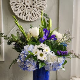Blue and white floral arrangement in a tall cobalt vase