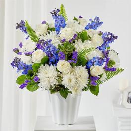 White and blue floral arrangement in a white vase