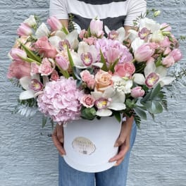 Large pink and white flower arrangement in a white hat box