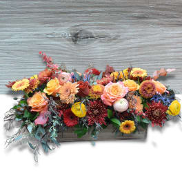 Mixed floral arrangement in a rectangular wooden planter