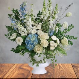White and blue floral arrangement in a white vase
