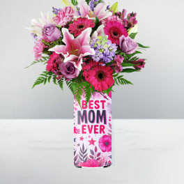 Tall pink and purple bouquet with lilies, roses, and gerbera daisies in a Best Mom Ever vase