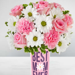 Pink roses, pink carnations, and white daisies in a tall vase labeled "Best Mom Ever".