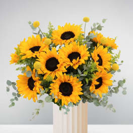 Bouquet of sunflowers in a tall cream vase