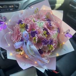 Pink and purple bouquet with a lavender ribbon and fairy lights