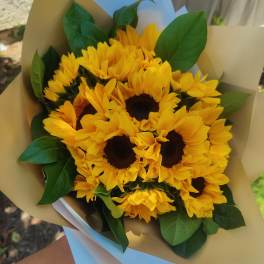 Bouquet of yellow sunflowers wrapped in tan paper