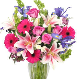 Mixed bouquet of pink roses, lilies, and gerbera daisies in a glass vase
