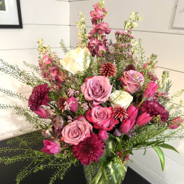 Pink and white mixed flower arrangement in a clear glass vase