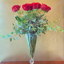 Tall bouquet of red roses in a clear glass vase