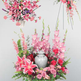 Pink lilies and roses arranged around a silver urn with tall floral sprays