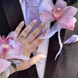 Pink orchid corsage and boutonniere with lavender ribbon on a suit jacket