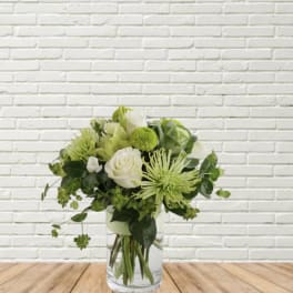 Green and white bouquet in a clear glass vase