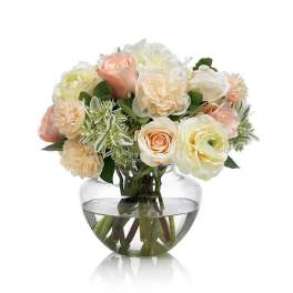 Bouquet of pale roses and cream flowers in a clear glass vase