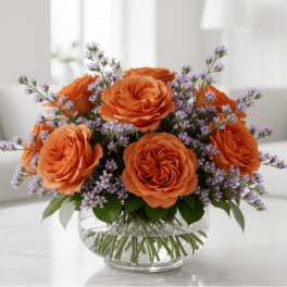 Orange roses with lavender filler in a clear glass vase