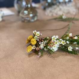 Small floral sprig with white and yellow blossoms on a table