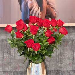 Red roses arranged in a reflective silver vase