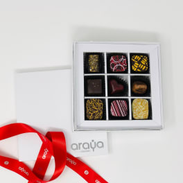Box of assorted chocolates with a red ribbon and card