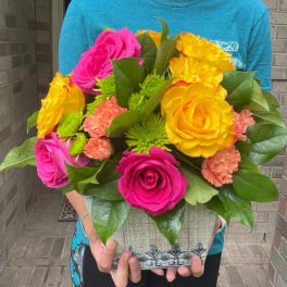 Bright mixed bouquet of pink and yellow roses in a decorative container