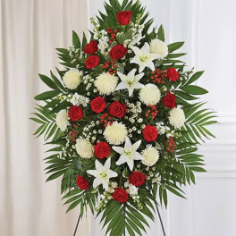 Standing floral spray with red roses, white lilies, and white pompons