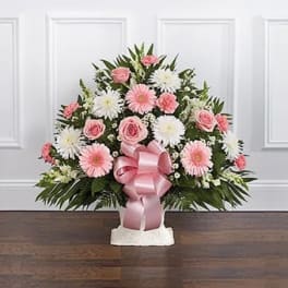 Pink and white floral arrangement with a pink ribbon in a white vase