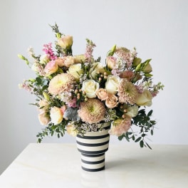 Pastel bouquet of roses and chrysanthemums in a striped vase