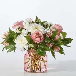 Pink roses and white daisies in a pink glass vase