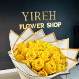 Bouquet of yellow roses wrapped in white and gold paper