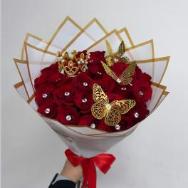 Bouquet of red roses with gold butterfly accents and a crown topper