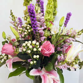 Pink and white mixed flower arrangement in a glass vase