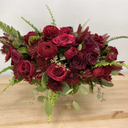 Deep red rose and chrysanthemum bouquet in a clear vase