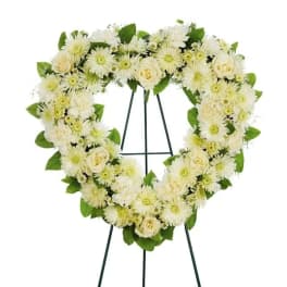Heart-shaped white floral wreath on a standing easel