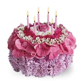 Pink floral cake with five lit candles