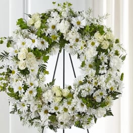 White floral wreath on a black stand