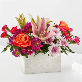Mixed bouquet of roses, lilies, and daisies in a square box
