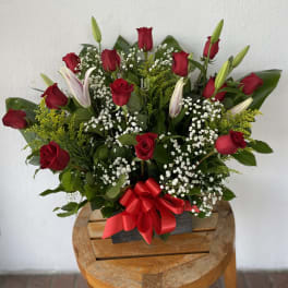 Bouquet of red roses and white lilies with baby's breath in a black box